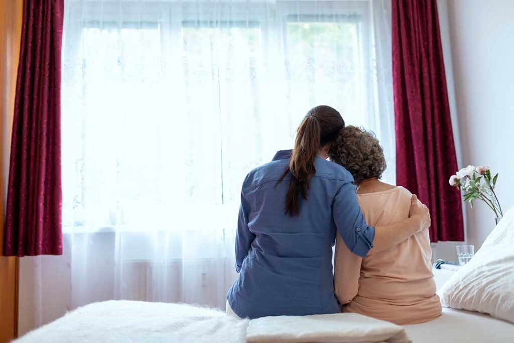 Family member and older adult touring a bright assisted living apartment with a staff guide