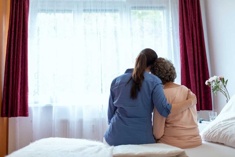 Family member and older adult touring a bright assisted living apartment with a staff guide